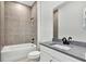 Bathroom featuring a combined tub and shower, modern vanity, and neutral tile at 17903 Palmiste Dr, Bradenton, FL 34202