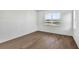 Minimalist bedroom features hardwood floors and a bright window offering a lake view at 17903 Palmiste Dr, Bradenton, FL 34202