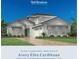 Avery Elite Caribbean home featuring a two-car garage, blue door, manicured landscaping and a beautiful paved driveway at 17903 Palmiste Dr, Bradenton, FL 34202