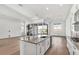 Bright, white kitchen featuring a large island with bar seating and stainless steel appliances at 17903 Palmiste Dr, Bradenton, FL 34202