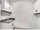 Laundry room with a sink, gray countertop, and storage cabinets at 17903 Palmiste Dr, Bradenton, FL 34202