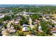 Expansive aerial view of a neighborhood with lush greenery and a home featuring solar panels on its roof at 2822 Maple Ave, Sarasota, FL 34234