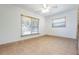Bright bedroom with tile flooring, a ceiling fan, and two windows at 2822 Maple Ave, Sarasota, FL 34234