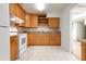 Well-lit kitchen featuring wood cabinetry, white appliances, and tile backsplash, creating a functional and inviting space at 2822 Maple Ave, Sarasota, FL 34234