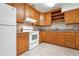 Well-lit kitchen featuring wood cabinetry, white appliances, and tile backsplash, creating a functional and inviting space at 2822 Maple Ave, Sarasota, FL 34234