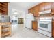 Bright kitchen featuring tile flooring, wooden shelving, white appliances, and wooden cabinets at 2822 Maple Ave, Sarasota, FL 34234