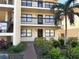 Inviting condo with a well-maintained exterior, complete with lush landscaping and a mature palm tree, offering curb appeal at 315 30Th W Ave # 101B, Bradenton, FL 34205