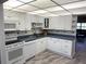 Well-lit kitchen with white cabinets, updated appliances, and a view into the living area at 315 30Th W Ave # 101B, Bradenton, FL 34205