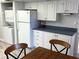 A compact kitchen space with stacked washer/dryer, refrigerator, with adjacent dining area at 315 30Th W Ave # 101B, Bradenton, FL 34205
