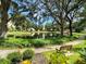 Picturesque view of a tranquil pond with a bench, surrounded by mature trees and lush greenery, offering a peaceful retreat at 315 30Th W Ave # 101B, Bradenton, FL 34205