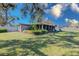 Expansive backyard with lush green grass, mature trees, and a screened-in lanai at 4147 Augustine Ave, Sarasota, FL 34231
