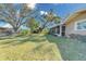 Large, green backyard featuring mature trees, chainlink fence, and screened-in lanai at 4147 Augustine Ave, Sarasota, FL 34231