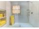 A modern shower with glass doors, yellow towels, and white tile walls at 4147 Augustine Ave, Sarasota, FL 34231