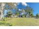 Wide view of home with a well-maintained lawn and mature trees at 4147 Augustine Ave, Sarasota, FL 34231
