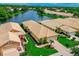 Aerial view of a lovely house with a tile roof and lush landscaping on a lakefront property at 4244 Reflections Pkwy, Sarasota, FL 34233