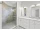 Bright bathroom featuring a marble countertop double vanity, a glass-enclosed shower with tile surround, and modern fixtures at 4244 Reflections Pkwy, Sarasota, FL 34233