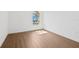 An empty bedroom with light brown flooring, white walls and baseboards, and a window providing natural light at 4244 Reflections Pkwy, Sarasota, FL 34233