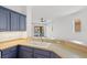 Modern kitchen featuring custom blue cabinets, a large sink, and views of the lake at 4244 Reflections Pkwy, Sarasota, FL 34233