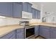 A kitchen featuring stainless steel appliances and unique blue cabinetry, offering a stylish and modern cooking space at 4244 Reflections Pkwy, Sarasota, FL 34233