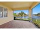 Screened lanai showing brick floor and view of lake with palm trees at 4244 Reflections Pkwy, Sarasota, FL 34233