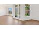 An open concept living space with a decorative glass front door, oversized windows, and new laminate floors at 4244 Reflections Pkwy, Sarasota, FL 34233