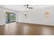 Large living room with wood floors, ample natural light, and sliding doors to patio at 4244 Reflections Pkwy, Sarasota, FL 34233