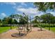 Community playground featuring a unique merry-go-round with swinging seats and a landscaped area at 4244 Reflections Pkwy, Sarasota, FL 34233