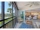 Comfortable lanai with wicker furniture and views of the pool and palm trees at 448 Gulf Of Mexico Dr # A204, Longboat Key, FL 34228