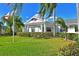 Inviting clubhouse exterior with well-maintained lawn, flags, and palm trees at 4722 Independence Dr, Bradenton, FL 34210