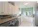 Bright kitchen and laundry area with white cabinets, granite countertops, and stainless steel appliances at 4722 Independence Dr, Bradenton, FL 34210