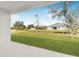 Relaxing backyard view showcasing the home and lush green landscape from the covered porch at 514 Santiguay St, Punta Gorda, FL 33983