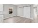 Open living area with wood flooring, a modern barn door, and natural light from a window at 514 Santiguay St, Punta Gorda, FL 33983