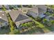 Bird's-eye view of a home featuring a screened-in pool area surrounded by tropical palm trees at 7812 Birdie Bend Way, Sarasota, FL 34241