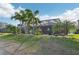 Expansive backyard featuring manicured lawn, mature palm trees, and screened-in outdoor living space at 7812 Birdie Bend Way, Sarasota, FL 34241