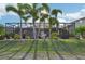 Beautiful backyard with lush grass, palm trees, and a screened lanai, perfect for relaxation at 7812 Birdie Bend Way, Sarasota, FL 34241