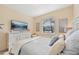 Bright bedroom features a large window, TV, and comfortable bedding for a relaxing space at 7812 Birdie Bend Way, Sarasota, FL 34241