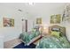 Bedroom featuring twin beds with tropical bedding, enhanced by vibrant artwork and bright lighting at 7812 Birdie Bend Way, Sarasota, FL 34241