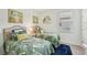 Charming bedroom features twin beds with tropical-themed bedding and decor with a blue rug for comfort at 7812 Birdie Bend Way, Sarasota, FL 34241