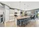 Gourmet kitchen with a large island, bar seating, and views of the dining area and living room at 7812 Birdie Bend Way, Sarasota, FL 34241