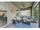 A comfortable lanai with wicker furniture, fan, and view of the lush landscaping at 7812 Birdie Bend Way, Sarasota, FL 34241