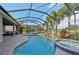 The screened in pool boasts a beautiful waterfall feature, mature landscaping, and golf course views at 7812 Birdie Bend Way, Sarasota, FL 34241