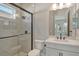 Modern bathroom featuring a tiled walk-in shower, gray tiling, and white vanity at 12440 Meribel St, Venice, FL 34293