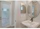 Stylish bathroom with a pedestal sink, decorative mirrors, and modern fixtures at 12440 Meribel St, Venice, FL 34293