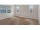 Bright bedroom featuring three windows with blinds and light wood flooring at 12440 Meribel St, Venice, FL 34293