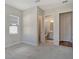Neutral bedroom featuring a connecting bathroom, window, and carpeted flooring at 12440 Meribel St, Venice, FL 34293