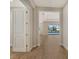 Hallway showcasing the wood-look flooring leading to views of the living area and a backyard pool at 12440 Meribel St, Venice, FL 34293