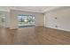 Spacious living room boasts wood-look flooring and a sliding glass door leading to the screened lanai and pool area at 12440 Meribel St, Venice, FL 34293