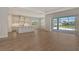 Open-concept living area showcasing wood-look floors, a kitchen with island, and backyard pool views at 12440 Meribel St, Venice, FL 34293