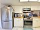 Kitchen with stainless steel fridge, oven, and view of open living area at 1407 Willow Oak Cir, Bradenton, FL 34209