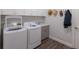 Well-equipped laundry room with white washer, dryer, sink, cabinets and wood-look flooring at 3023 Vittorio Ct, Lakewood Ranch, FL 34211